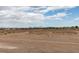 Distant view of home exteriors surrounded by dry landscape in the desert environment, visible under a partly cloudy sky at 8070 W Russell Rd # 2026, Las Vegas, NV 89113
