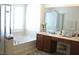 Bright bathroom featuring a soaking tub, vanity with storage, and shower with glass door at 8139 Retriever Ave, Las Vegas, NV 89147