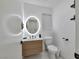 Modern bathroom featuring a circular mirror, floating vanity, and white fixtures at 8404 Shore Breeze Dr, Las Vegas, NV 89128