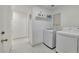 Neat laundry room featuring a modern washer and dryer with white marble tile floors at 8404 Shore Breeze Dr, Las Vegas, NV 89128