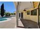 A covered patio is connected to a sparkling pool and the backyard is fully fenced, offering comfort and privacy at 8705 Orvieto Dr, Las Vegas, NV 89117