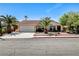 Charming single-story home with a lush front yard, palm trees, and a two-car garage at 8705 Orvieto Dr, Las Vegas, NV 89117