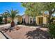 Home exterior featuring landscaped yard with desert rock and mature trees at 8705 Orvieto Dr, Las Vegas, NV 89117
