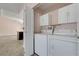 Bright laundry area features a washer, dryer, white cabinets, and tile flooring, adding convenience to the home at 8705 Orvieto Dr, Las Vegas, NV 89117