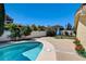 The backyard features a sparkling pool with a tanning deck, spa, a lush lawn, and established landscaping at 8705 Orvieto Dr, Las Vegas, NV 89117