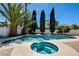 A refreshing swimming pool and spa is surrounded by tropical landscaping creating a private and relaxing oasis at 8705 Orvieto Dr, Las Vegas, NV 89117