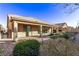 Exterior view of home with covered patio and easy to maintain landscaped backyard at 8797 Pinley Spring St, Las Vegas, NV 89113