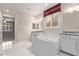 Bright bathroom features a soaking tub with marble surround and granite countertops at 8797 Pinley Spring St, Las Vegas, NV 89113