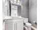 Elegant bathroom with a vessel sink on a white vanity, a toilet, and gray textured wallpaper at 8797 Pinley Spring St, Las Vegas, NV 89113