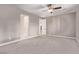 Spacious bedroom featuring neutral carpet, gray walls, ceiling fan, and white trim at 8797 Pinley Spring St, Las Vegas, NV 89113