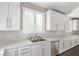 Gourmet kitchen features white cabinetry, quartz countertops, stainless appliances, and tile backsplash at 8797 Pinley Spring St, Las Vegas, NV 89113
