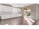 Bright open concept kitchen featuring hardwood floors, white cabinets, and sliding glass doors at 8797 Pinley Spring St, Las Vegas, NV 89113