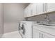 Bright laundry room with a sink, counter space, overhead cabinets and front-load washer and dryer at 8797 Pinley Spring St, Las Vegas, NV 89113