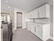 Bright living area featuring a bar with white cabinets, granite counters, and an adjacent pantry at 8797 Pinley Spring St, Las Vegas, NV 89113