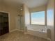 Well-lit bathroom with a soaking tub, separate glass-enclosed shower, and large window at 9138 Hermosa Valley St, Las Vegas, NV 89178