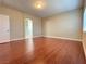 Bedroom with hardwood floors, neutral colored walls, white trim and doorway to a bathroom at 9138 Hermosa Valley St, Las Vegas, NV 89178