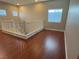Bright upstairs hallway with hardwood floors, natural light, and white banister and trim details at 9138 Hermosa Valley St, Las Vegas, NV 89178