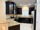 Kitchen features dark cabinets, granite countertops, and stainless steel appliances at 9138 Hermosa Valley St, Las Vegas, NV 89178