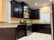 A kitchen featuring stainless steel appliances and dark wood cabinets and tile flooring at 9138 Hermosa Valley St, Las Vegas, NV 89178