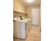 Laundry room with tiled floors, two machines, and a white door at 9138 Hermosa Valley St, Las Vegas, NV 89178