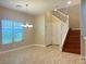 Neutral living room featuring tile flooring, a large window, and staircase access at 9138 Hermosa Valley St, Las Vegas, NV 89178