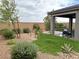 A charming backyard featuring desert landscaping, decorative gravel, and a covered patio for outdoor living at 929 Hunter Shores Ave, North Las Vegas, NV 89084