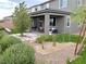 Backyard features an outdoor seating and dining area, desert landscaping, and hardscape with mature trees at 929 Hunter Shores Ave, North Las Vegas, NV 89084