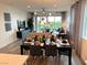 A dining room with a table set for a meal, an overhead fan and light fixture, and an open view to the backyard at 929 Hunter Shores Ave, North Las Vegas, NV 89084
