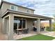 Covered outdoor patio with modern table and chairs, manicured backyard landscaping and hardscape, plus ceiling fans at 929 Hunter Shores Ave, North Las Vegas, NV 89084