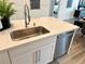 Modern kitchen island featuring a stainless steel sink, dishwasher, and white cabinets at 929 Hunter Shores Ave, North Las Vegas, NV 89084