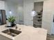 Modern kitchen featuring an island, sink, faucet, pendant lighting, and a view of the pantry at 929 Hunter Shores Ave, North Las Vegas, NV 89084