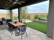 Covered outdoor patio with modern table and chairs, manicured backyard landscaping and hardscape, plus ceiling fans at 929 Hunter Shores Ave, North Las Vegas, NV 89084