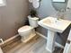 Stylish powder room with a pedestal sink, toilet, and decorative wall accents at 929 Hunter Shores Ave, North Las Vegas, NV 89084