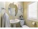 Cozy bathroom with a pedestal sink, round mirror, and natural light at 9823 Belle Marie Ct, Las Vegas, NV 89141