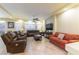 Open-concept living room with leather seating and bright natural light at 9823 Belle Marie Ct, Las Vegas, NV 89141