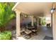 Inviting covered patio with outdoor dining table and desert landscaping creates a relaxing space at 9823 Belle Marie Ct, Las Vegas, NV 89141