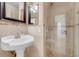 Updated bathroom featuring pedestal sink, framed mirror, tiled shower, and glass door at , Henderson, NV 89011