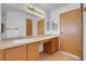 This bathroom features dual sinks, warm vanity lighting, and neutral wood-look flooring at , Henderson, NV 89011