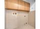 Laundry room featuring tiled walls, floor, upper cabinets, and washer/dryer hookups at , Henderson, NV 89011