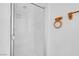 The bathroom features a walk-in shower with white tiling, a glass door, and a towel rack at , Henderson, NV 89011