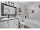 Updated bathroom features a modern vanity, marble-look tiled walls, tub with shower head, and floating shelves at 1025 Willow Tree Dr # B, Las Vegas, NV 89128