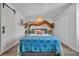 Bright bedroom with a colorful accent wall, wood-look floors, and stylish sliding barn door at 1025 Willow Tree Dr # B, Las Vegas, NV 89128