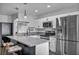 Well-lit kitchen featuring stainless steel appliances, quartz countertops, and a breakfast bar with seating at 1025 Willow Tree Dr # B, Las Vegas, NV 89128
