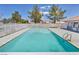 Inviting outdoor pool with clear blue water surrounded by well-maintained fencing and mature trees at 1025 Willow Tree Dr # B, Las Vegas, NV 89128