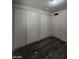 A bedroom with gray plank floors features two closets and a ceiling light at 1317 Exley Ave, Las Vegas, NV 89104