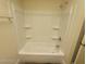Bathtub and shower with tiled walls and storage shelves at 1317 Exley Ave, Las Vegas, NV 89104