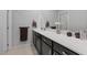 Well-lit bathroom with a long vanity, white quartz countertops, dark cabinets, and modern fixtures at 143 Aqua Commons Ln, Henderson, NV 89015