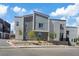 View of townhouses featuring a neutral color scheme, modern windows and landscaping at 143 Aqua Commons Ln, Henderson, NV 89015