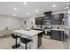 Modern kitchen with an island, breakfast bar, dark cabinets, stainless steel appliances and tiled backsplash at 143 Aqua Commons Ln, Henderson, NV 89015