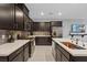Modern kitchen featuring dark cabinets, stainless steel appliances, white quartz countertops, and stylish backsplash at 143 Aqua Commons Ln, Henderson, NV 89015